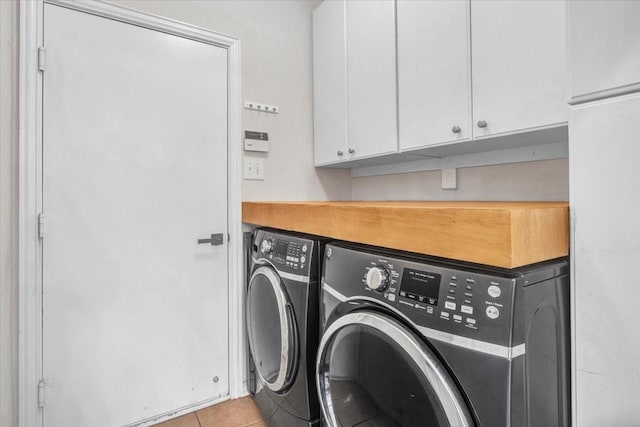 laundry room featuring cabinets, washing machine and dryer, and light tile patterned floors