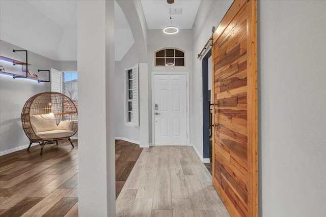 foyer entrance featuring hardwood / wood-style flooring and a barn door