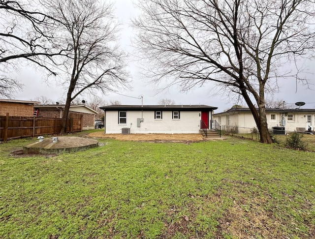 back of house with central AC and a lawn