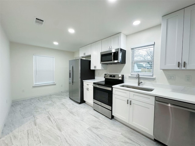 kitchen featuring appliances with stainless steel finishes, sink, and white cabinets