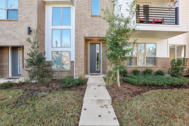 view of exterior entry featuring a balcony