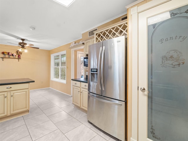 kitchen featuring stainless steel refrigerator with ice dispenser, light tile patterned floors, ornamental molding, ceiling fan, and cream cabinetry