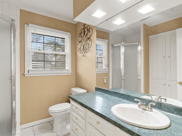 bathroom featuring a healthy amount of sunlight, tile patterned floors, a shower with shower door, and vanity