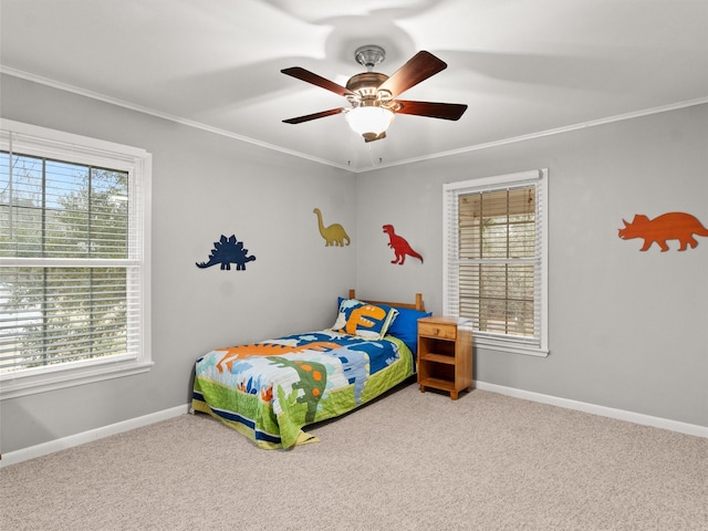 carpeted bedroom with ornamental molding and ceiling fan