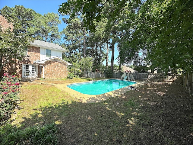 view of pool with a yard