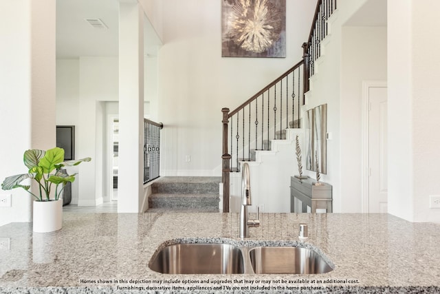 foyer featuring sink and a towering ceiling