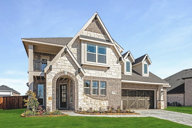 view of front facade with a front lawn, fence, a shingled roof, a garage, and brick siding