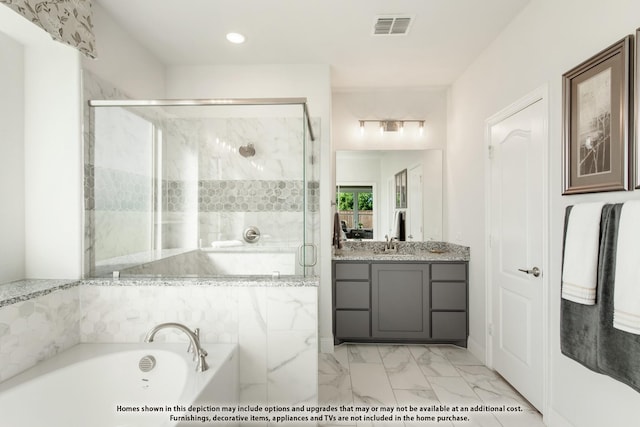 bathroom with vanity and shower with separate bathtub