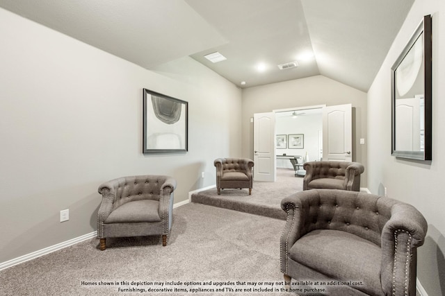 living area featuring lofted ceiling and carpet