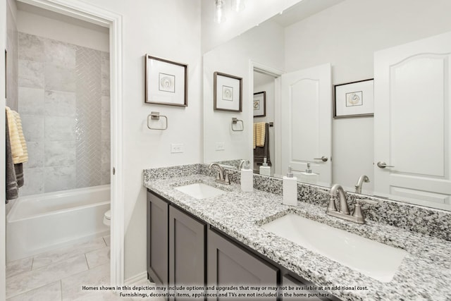 full bathroom featuring tiled shower / bath, vanity, toilet, and tile patterned floors