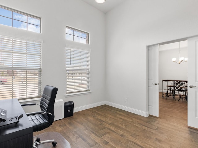 office area featuring an inviting chandelier, wood-type flooring, and a healthy amount of sunlight