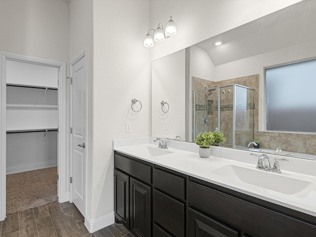 bathroom featuring vanity, a shower with shower door, and vaulted ceiling