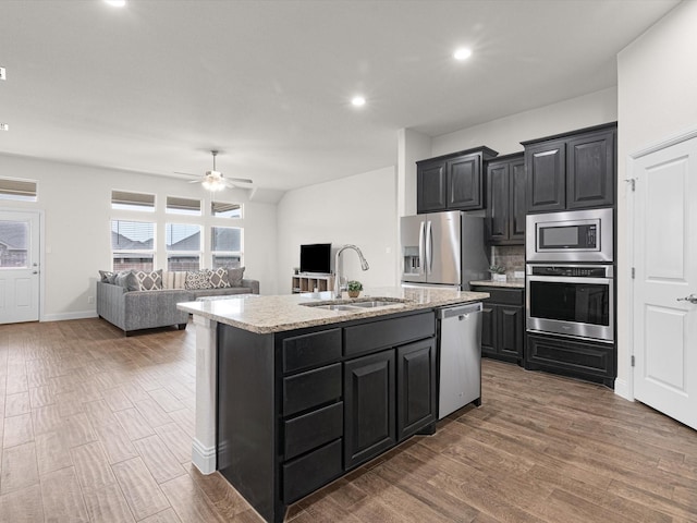 kitchen featuring dark hardwood / wood-style floors, sink, a kitchen island with sink, ceiling fan, and stainless steel appliances