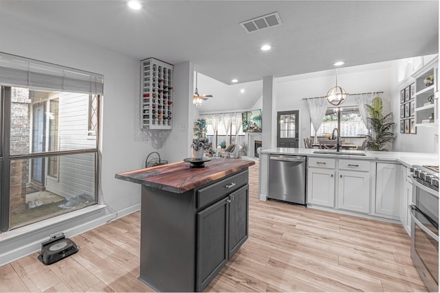 kitchen featuring visible vents, a sink, appliances with stainless steel finishes, wood counters, and light wood-type flooring