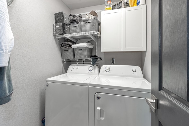 clothes washing area featuring cabinet space, independent washer and dryer, and a textured wall