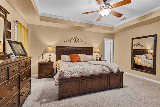 bedroom with a tray ceiling, visible vents, light carpet, and ornamental molding