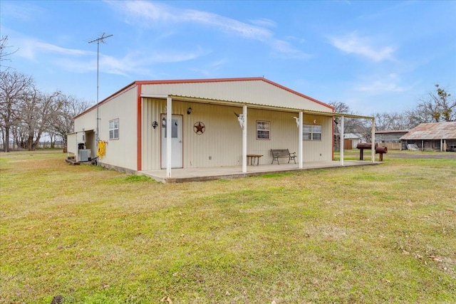 rear view of property featuring a lawn, central AC, and a patio