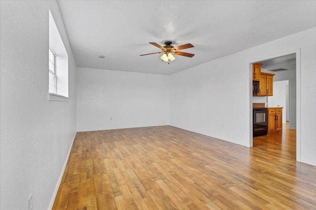 unfurnished room featuring visible vents, baseboards, light wood finished floors, and ceiling fan