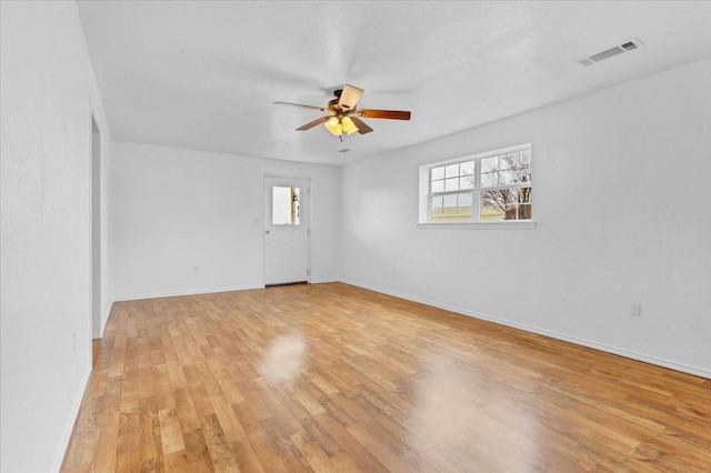 unfurnished room with light wood finished floors, visible vents, ceiling fan, and a healthy amount of sunlight