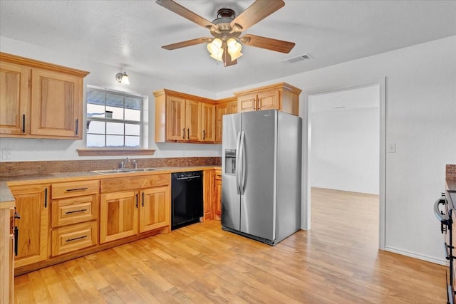 kitchen featuring visible vents, stainless steel fridge, black dishwasher, a ceiling fan, and a sink