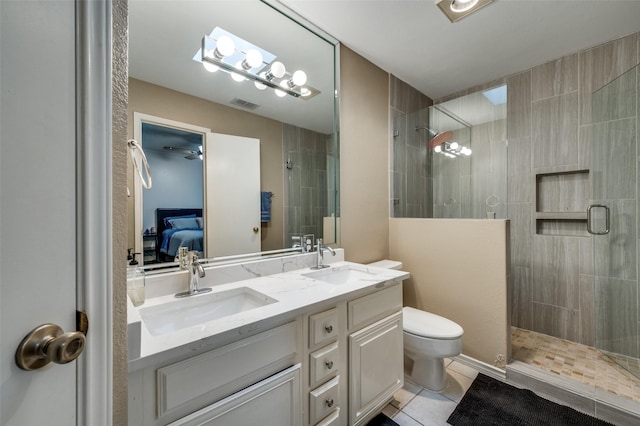 bathroom featuring toilet, vanity, tile patterned flooring, and an enclosed shower