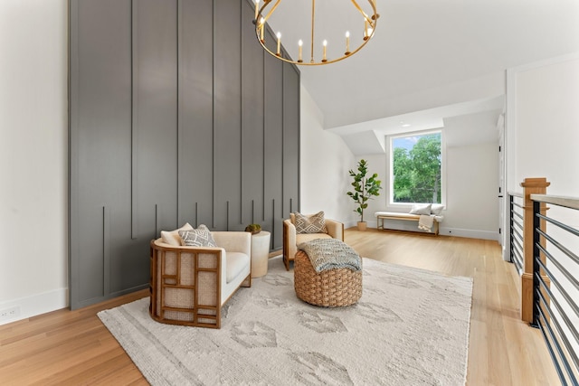 sitting room featuring light hardwood / wood-style flooring, high vaulted ceiling, and a chandelier