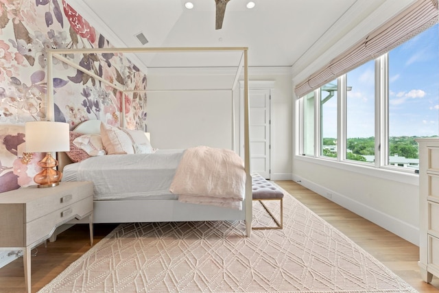 bedroom with ornamental molding and light wood-type flooring