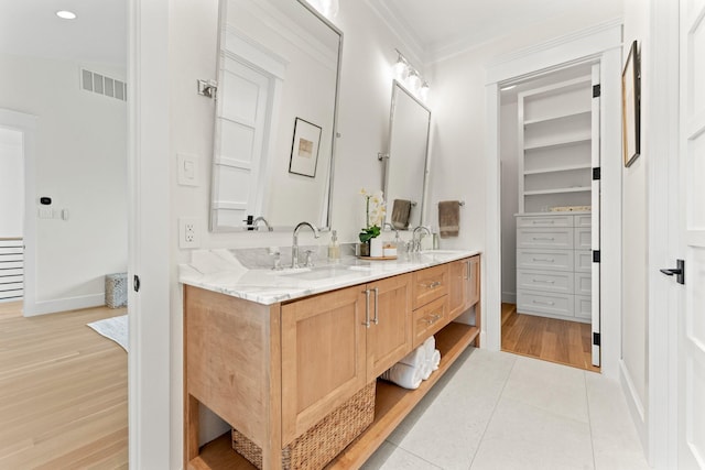 bathroom featuring tile patterned flooring, vanity, and crown molding