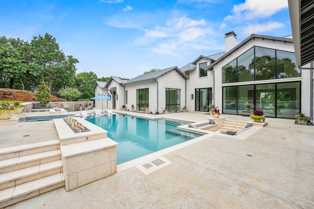 view of swimming pool featuring a fire pit and a patio area