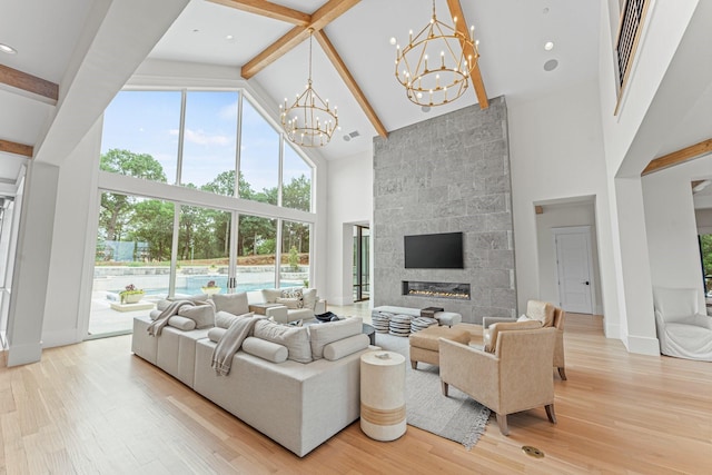 living room featuring an inviting chandelier, high vaulted ceiling, a fireplace, wood-type flooring, and beam ceiling