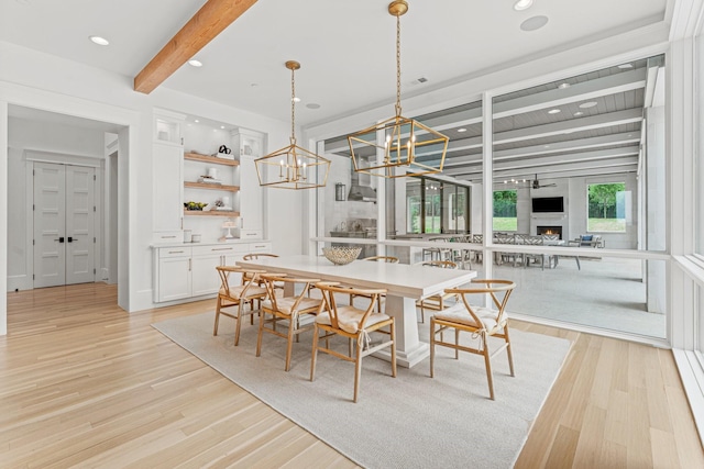 dining space featuring beamed ceiling and light hardwood / wood-style flooring