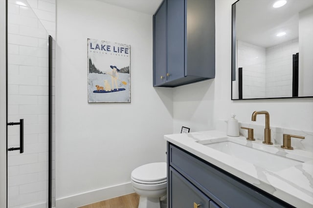 bathroom with hardwood / wood-style flooring, vanity, toilet, and a shower with door