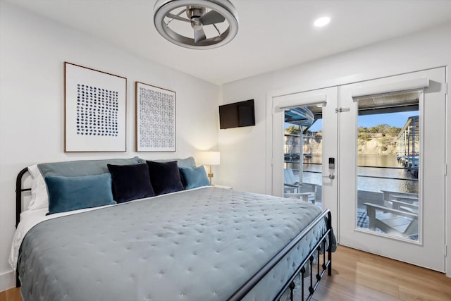 bedroom with access to outside, light hardwood / wood-style floors, and french doors