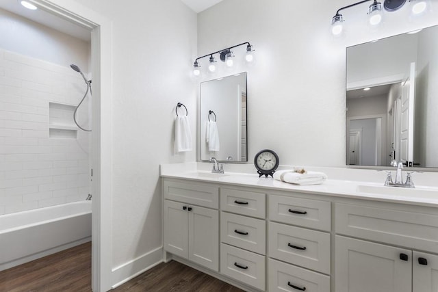 bathroom with tiled shower / bath, wood-type flooring, and vanity