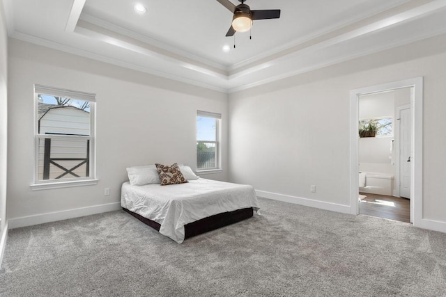 bedroom featuring a tray ceiling, carpet floors, ornamental molding, and ensuite bathroom