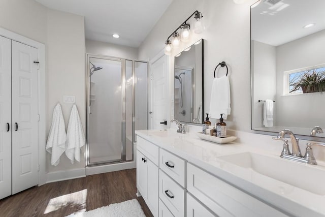 bathroom featuring vanity, hardwood / wood-style flooring, and a shower with shower door