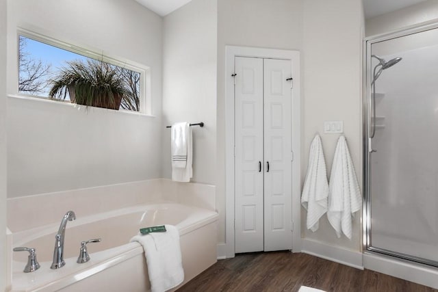 bathroom with hardwood / wood-style flooring and independent shower and bath