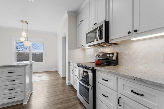 kitchen with white cabinetry, pendant lighting, ornamental molding, and stainless steel appliances