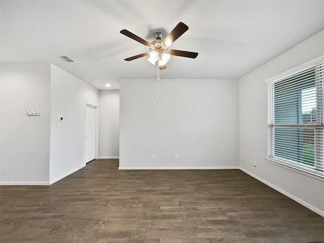 empty room featuring dark wood-type flooring and ceiling fan