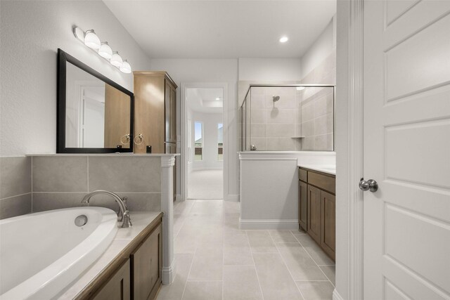 full bathroom with a stall shower, tile patterned flooring, a bath, and vanity