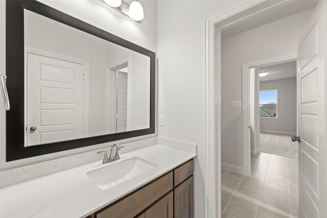 bathroom featuring tile patterned flooring, vanity, and baseboards