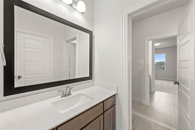 bathroom with tile patterned flooring, baseboards, and vanity