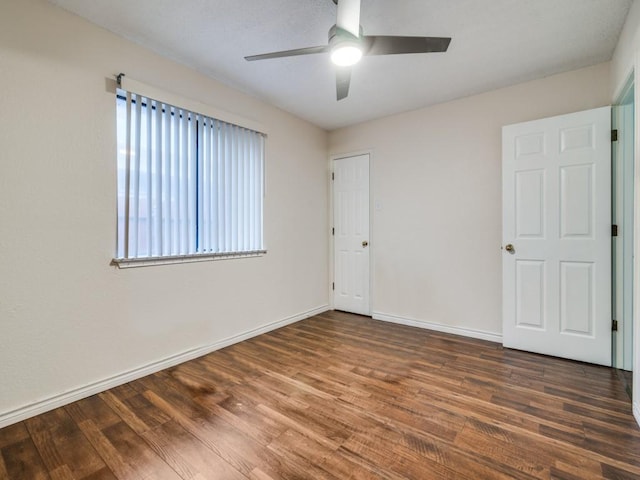 unfurnished room with dark hardwood / wood-style flooring and ceiling fan