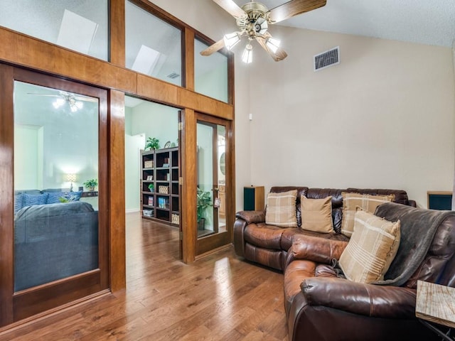 living room featuring ceiling fan, high vaulted ceiling, and hardwood / wood-style floors