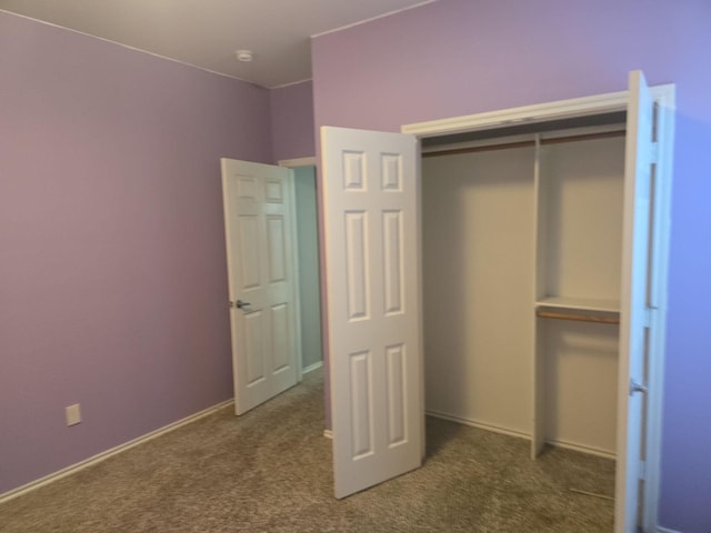 unfurnished bedroom featuring a closet and dark colored carpet