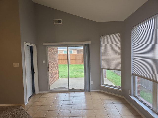 doorway featuring vaulted ceiling and light tile patterned floors