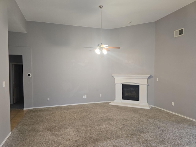 unfurnished living room with carpet flooring and ceiling fan