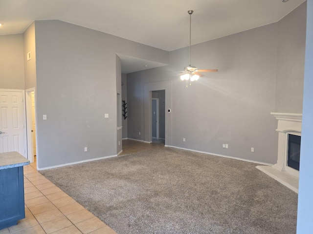 unfurnished living room with light carpet, vaulted ceiling, and ceiling fan