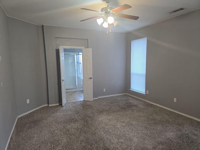 spare room with ceiling fan and light carpet