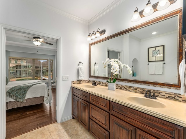 bathroom featuring crown molding, ceiling fan, tile patterned flooring, backsplash, and vanity